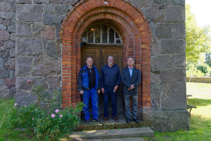 v. li. Udo Griwahn, xxxxxxxxxxxxxx, Pastor Rupert Schröder vor der Kirche in Neuendorf B